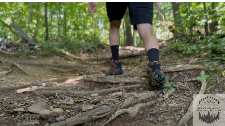 Merrell Moab 3 hiking boots on a uneven trail, showcasing their durability and design.
