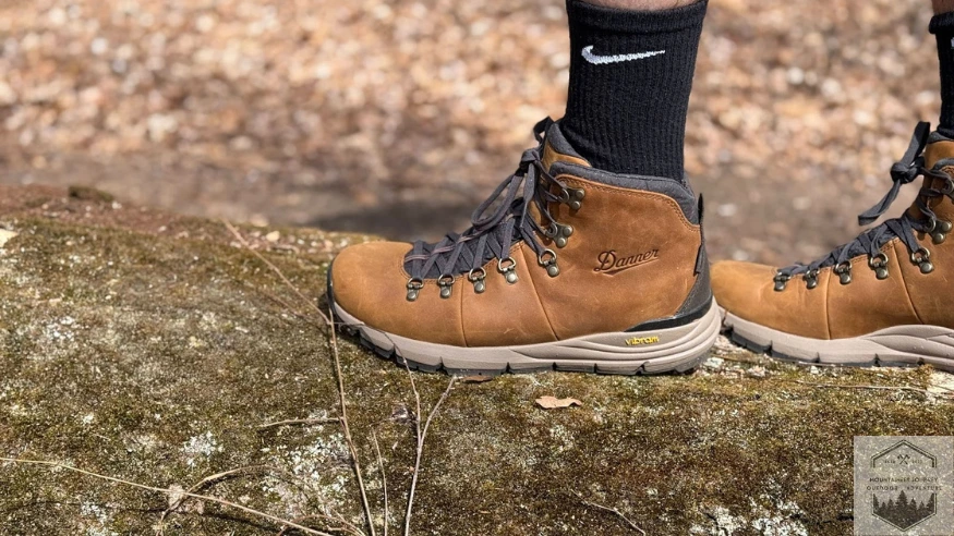 Showing the Vibram megarip outsole holding grip onto a large tree branch on the ground