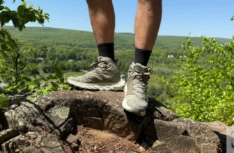 Standing at the top of a rock wearing the Hoka Anacapa Breeze Mid's