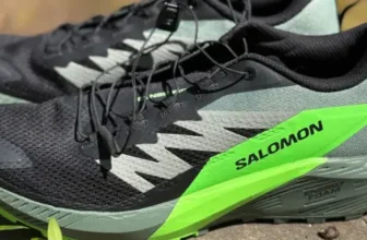 view of both salomon sense ride 5 shoes on a wall. Revealing the high heel stack height and higher heel to toe drop