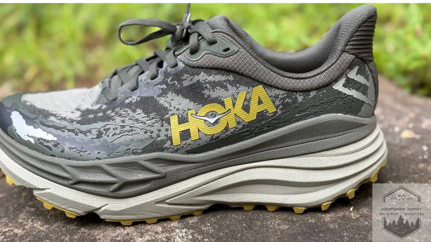 side view of the hoka stinson 7 on wall (green camo version)