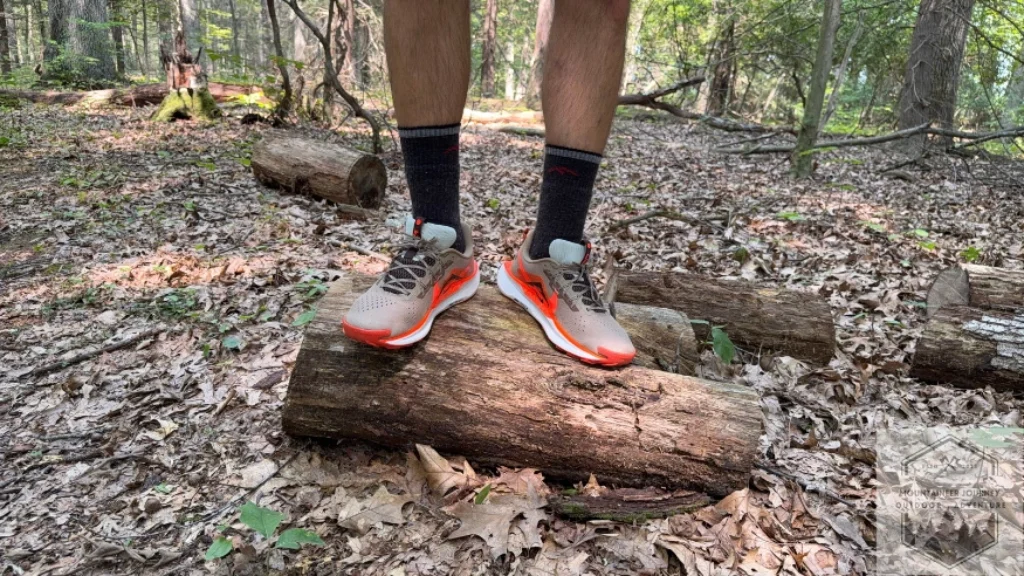 Standing on a log wearing the Nike Pegasus Trail 5, showing the stack height