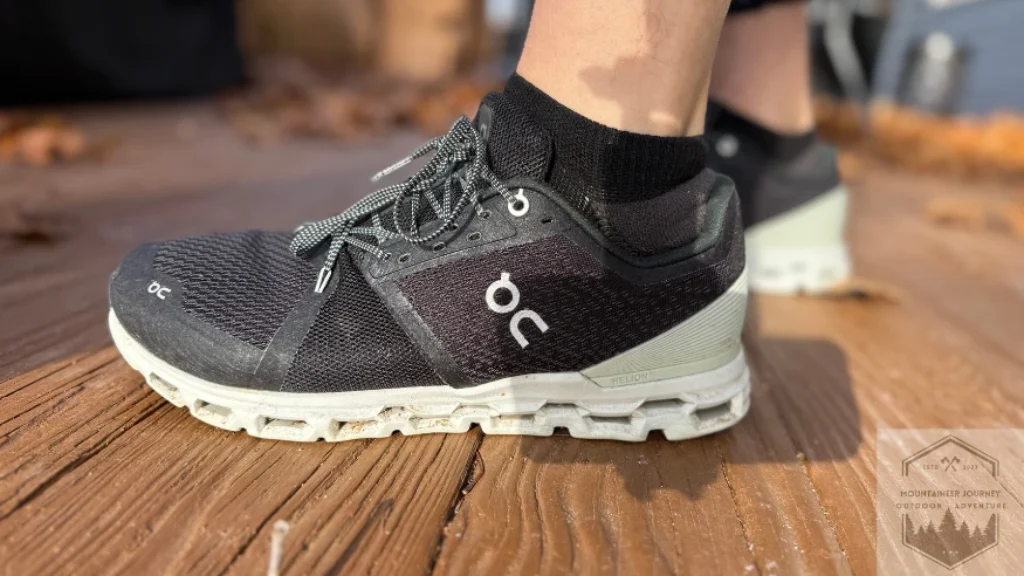 side profile view of the On Cloud 6 pair on a wood surface, highlighting the sleek urban design and the signature speed lacing system for easy travel and daily wear.